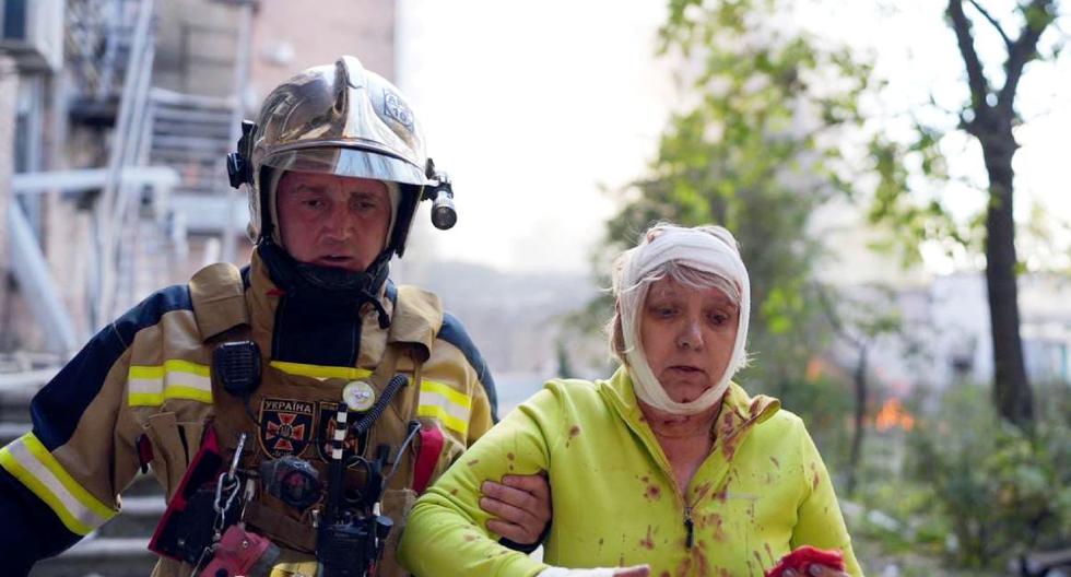 Un rescatista ayuda a una mujer herida en el lugar del bombardeo en Kiev, Ucrania, el 10 de octubre de 2022. (AFP).