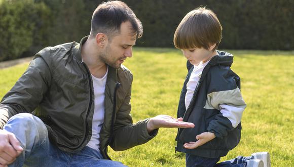 Padre le pide a su hijo pequeño que le muestre la astilla que se ha incrustado en su mano.