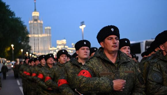 Los cosacos rusos marchan con el rascacielos de la era de Stalin cuando llegan al ensayo del desfile militar del Día de la Victoria en el centro de Moscú, el 27 de abril de 2023. Rusia celebrará el 78 aniversario de la victoria de 1945 sobre la Alemania nazi el 9 de mayo. (Foto de Kirill KUDRYAVTSEV / AFP)