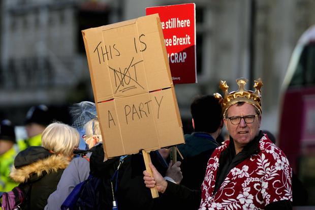 Manifestantes protestan contra Boris Johnson antes de su presentación en el Parlamento, donde se disculpó por haber asistido a un evento social en pleno confinamiento.  (AP Photo/Frank Augstein)