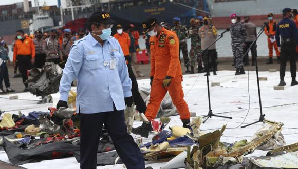 Un investigador del Comité Nacional de Seguridad en el Transporte de Indonesia (KNKT) inspecciona los escombros encontrados en las aguas alrededor del lugar donde se estrelló el avión de pasajeros de Sriwijaya Air, en el puerto de Tanjung Priok en Yakarta, Indonesia. (Foto: AP / Achmad Ibrahim)