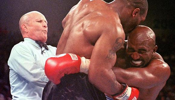 El árbitro Lane Mills interviene cuando Evander Holyfield reacciona después de que Mike Tyson le mordiera la oreja en su pelea del el 28 de junio de 1997. (AFP FOTO/JEFF HAYNES).