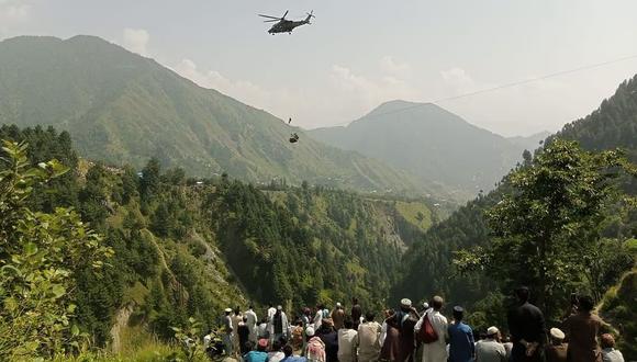 Rescate en helicóptero de uno de los menores de edad, del grupo de ocho personas, que este lunes quedó atrapado en un teleférico en Pakistán. (Foto: Captura de video)