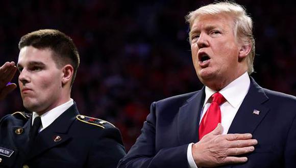 Trump canta el himno nacional en la previa al partido Alabama y Georgia. (Foto: Reuters)