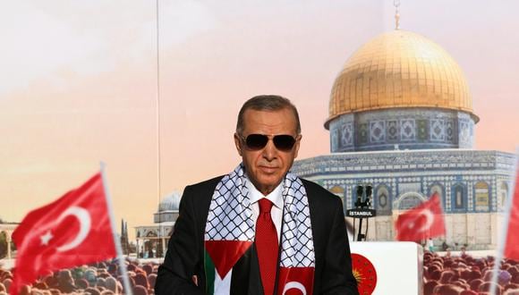 El presidente turco, Tayyip Erdogan, con un pañuelo con las banderas palestina y turca, está en el escenario durante una manifestación organizada por el partido AKP en solidaridad con los palestinos en Gaza, en Estambul el 28 de octubre de 2023. (Foto de FOLLETO / OFICINA DE PRENSA DE LA PRESIDENCIA TURCA / AFP)
