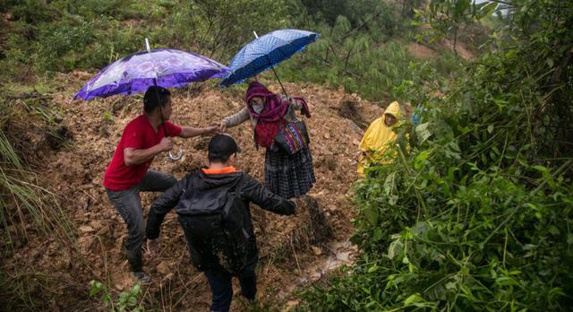 Pobladores cruzan a través de caminos improvisados por los derrumbes ocasionados por el paso de la depresión tropical Eta, hoy en Purulha (Guatemala). (EFE/ Esteban Biba).