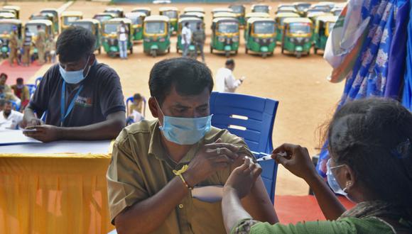 Un conductor de rickshaw automático recibe una inyección de la vacuna CoviShield contra el coronavirus durante una campaña de vacunación gratuita en Bangalore (India), el 25 de agosto de 2021. (Foto de Manjunath Kiran / AFP).