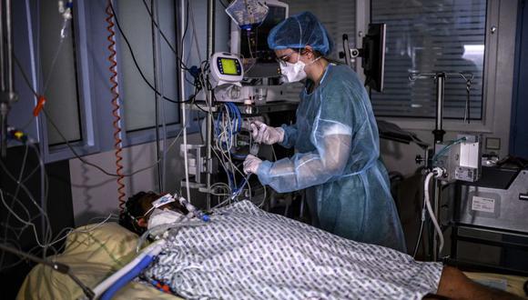 Una enfermera brinda tratamiento a un paciente con Covid-19 bajo asistencia respiratoria, en una habitación de la unidad de cuidados intensivos del hospital AP-HP Cochin en París, ya que el número de personas hospitalizadas está en el auge de la capital francesa. (Foto: Christophe ARCHAMBAULT / AFP).