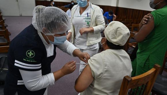 Una trabajadora de salud inmuniza a su colega con una dosis de la vacuna AstraZeneca / Oxford Covid-19 en Santa Cruz, Bolivia. (Foto: archivo/ AIZAR RALDES / AFP).