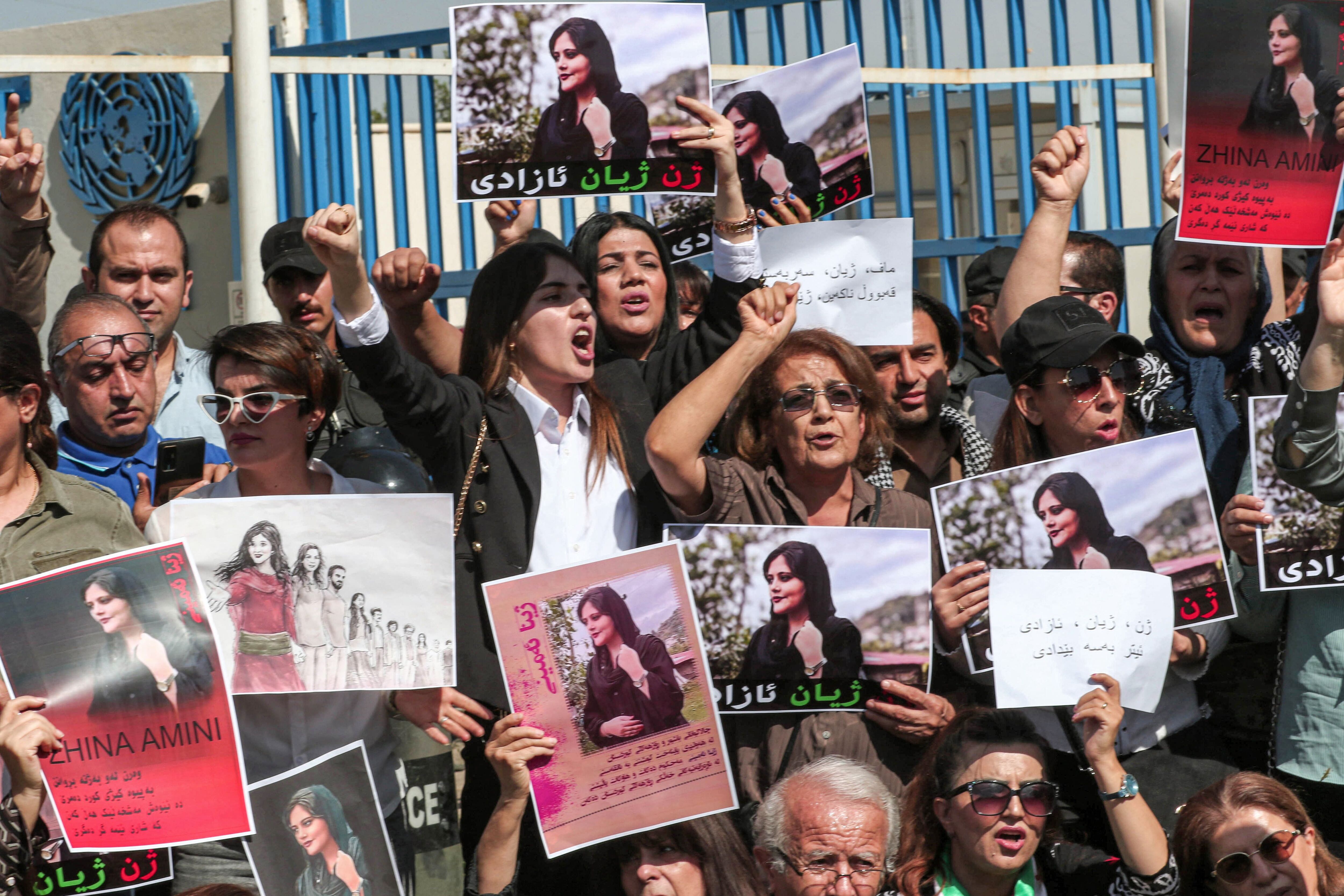 Women chant slogans and hold banners bearing the image of 22-year-old Mahsa Amini, who died in the custody of Iranian authorities, during a demonstration denouncing her death by Iraqi and Iranian Kurds in front of the UN offices in Arbil, the capital of Iran.  (Photo by SAFIN HAMED / AFP)