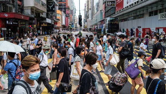 Peatones que usan mascarilla para protegerse del coronavirus caminan por una avenida principal en Hong Kong el 20 de julio de 2020. (Foto: ANTHONY WALLACE / AFP).