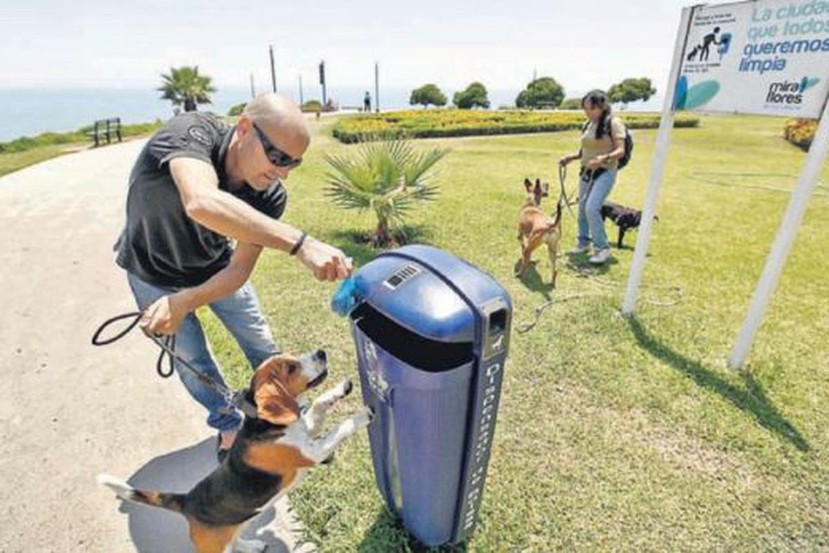 Dispensador bolsa de caca de perro en un parque público Fotografía