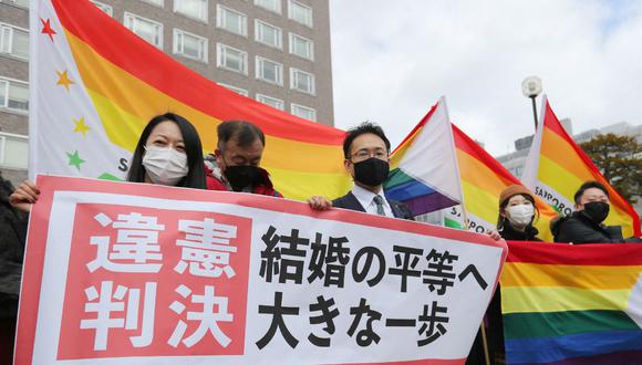 Activistas sostienen las banderas del colectivo gay frente al Tribunal de Distrito de Sapporo, prefectura de Hokkaido, Japón, el 17 de marzo de 2021. (Foto de STR / JIJI PRESS / AFP).