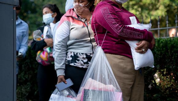 Migrantes de Venezuela, que abordaron un autobús en Texas, esperan ser transportados a una iglesia local por voluntarios después de ser dejados frente a la residencia de la vicepresidenta de EE. UU. Kamala Harris, en el Observatorio Naval en Washington, DC, el 15 de septiembre de 2022 (Foto: Stefani Reynolds / AFP)
