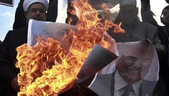 Un palestino sostiene una foto en llamas del presidente de EE.UU., Donald Trump, durante una protestas contra el mandatario. (Foto: AP)