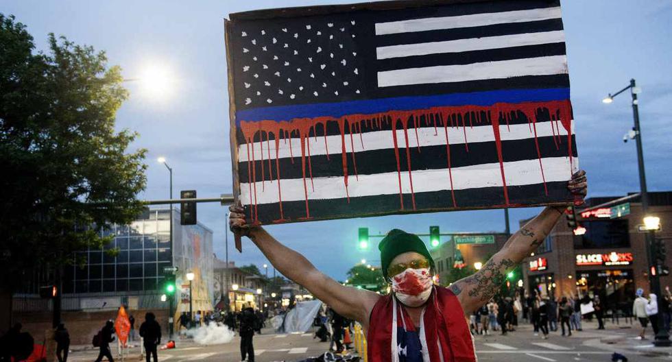 Manifestantes con la bandera de USA en negro. (Foto: Jason Connolly / AFP)