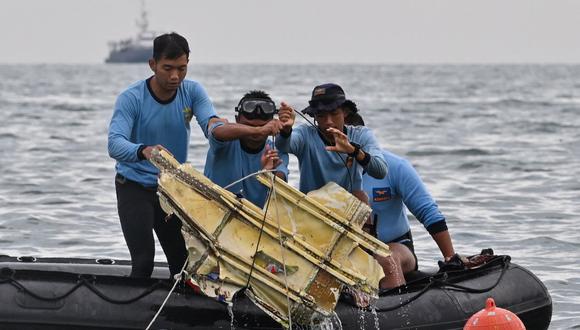 Buzos de la Armada de Indonesia sacan los restos del vuelo SJY182 de Sriwijaya Air durante una operación de búsqueda y rescate en el mar cerca de la isla Lancang el 10 de enero de 2021. (Foto de ADEK BERRY / AFP).