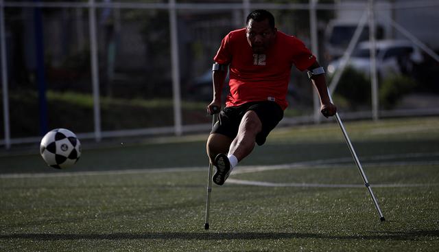 Alexander Pérez patea un balón durante un entrenamiento de fútbol de amputados en una cancha sintética en Panamá. (EFE)