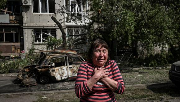 Una mujer reacciona frente a un edificio de apartamentos dañado después de un bombardeo ruso en la ciudad de Slovyansk, en la región de Donbás, en el este de Ucrania, el 31 de mayo de 2022. (ARIS MESINIS / AFP).