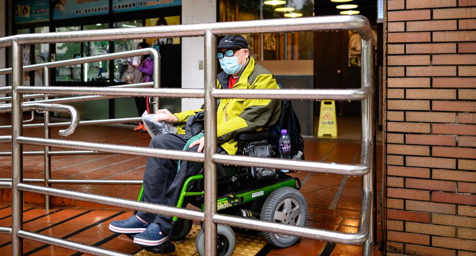 Steven Yan es un paciente con atrofia muscular, montado en su silla de ruedas, el paciente espera en la estación de buses para comprar mascarillas. (Foto: AFP)