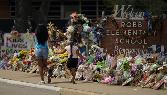 Los visitantes pasan frente a un monumento improvisado en honor a los asesinados recientemente en la Escuela Primaria Robb, en Uvalde, Texas.