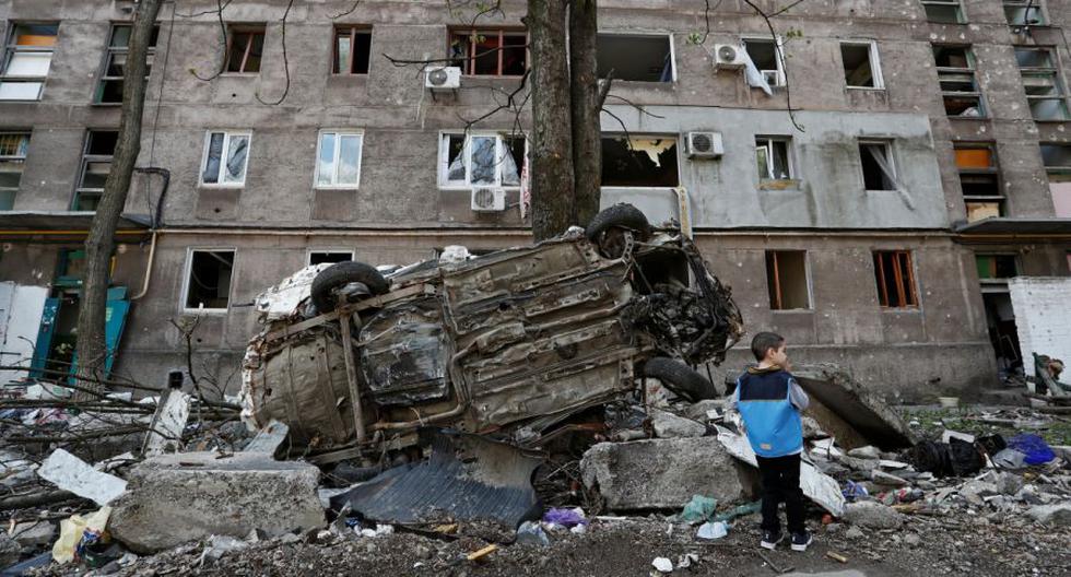 Un niño junto a un vehículo destrozado frente a un edificio de apartamentos dañado durante el conflicto entre Ucrania y Rusia en la ciudad portuaria sureña de Mariupol, Ucrania. (Foto: Reuters)
