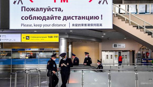 Oficiales de policía con mascarillas por el coronavirus en la terminal F del aeropuerto Sheremetyevo de Moscú, Rusia, el 4 de abril de 2020. (Yuri KADOBNOV / AFP).