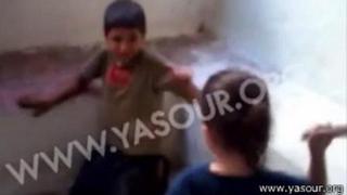 Una niña le pega a un refugiado sirio alentada por sus padres