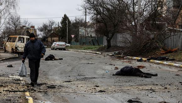 Un hombre camina por una calle de Bucha donde hay varios cadáveres tras la retirada de las fuerzas rusas. (RONALDO SCHEMIDT / AFP).