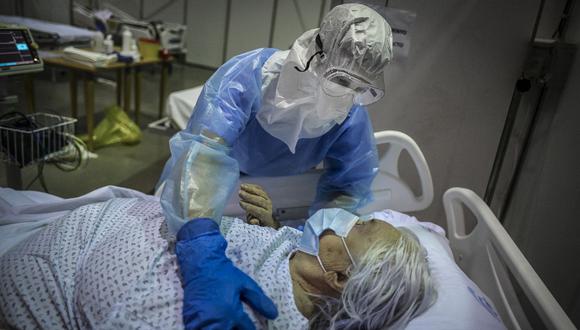Personal sanitario atiende a una paciente de coronavirus en un hospital de campaña de Portugal. (Foto de PATRICIA DE MELO MOREIRA / AFP).