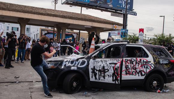 Manifestantes vandalizan un carro de la policía de Los Ángeles durante una protesta por el asesinato de George Floyd a manos de la policía de Minneapolis. (Foto ARIANA DREHSLER / AFP).