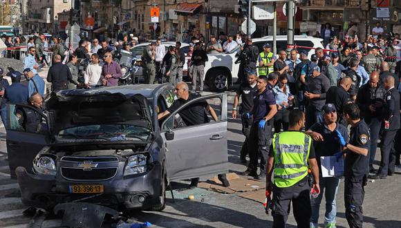 La policía israelí y el personal de emergencia inspeccionan un vehículo dañado luego de un incidente en el mercado Mahane Yehuda de Jerusalén el 24 de abril de 2023. (Foto de AHMAD GHARABLI / AFP)