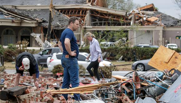 En esta foto de archivo tomada el 31 de marzo de 2023, Kris French (C) y su familia buscan entre los escombros una grabadora de video que creen que capturó un tornado directo a su negocio, Champs Car Wash, después de que un tornado dañó cientos de casas y edificios en Little Rock, Arkansas. (Foto de Benjamin Krain / AFP)