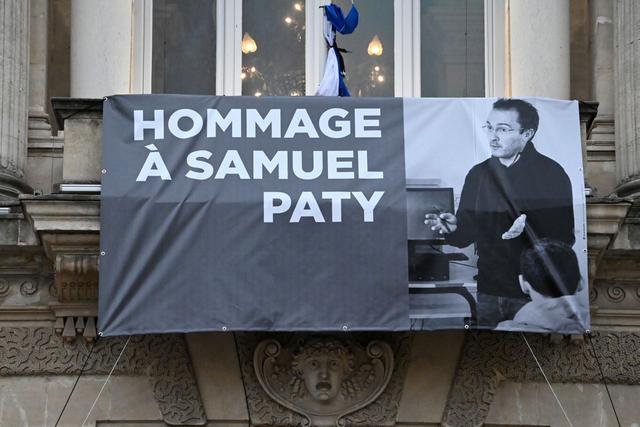 Un retrato del profesor de francés Samuel Paty en la fachada de la Opera Comedie en Montpellier el 21 de octubre de 2020, durante un homenaje nacional al maestro que fue decapitado por mostrar dibujos del profeta Mahoma en su clase de educación cívica. (Foto de Pascal GUYOT / AFP).