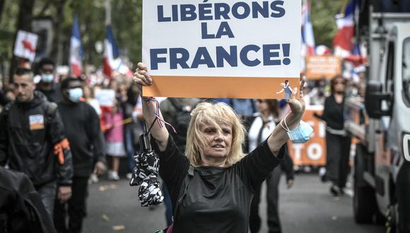 Una manifestante sostiene un cartel durante una protesta contra el pase de salud obligatorio Covid-19 para acceder a la mayor parte del espacio público en Francia. (Foto de STEPHANE DE SAKUTIN / AFP).