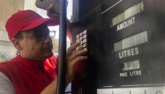 Foto del 22 de septiembre de 2021 de un trabajador de una gasolinera en Beirut, Líbano, tratando de fijar el nuevo precio de la gasolina. (AP Foto/Hussein Malla, Archivo).