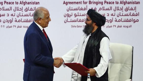 El representante especial de Estados Unidos para la reconciliación en Afganistán, Zalmay Khalilzad, da la mano al cofundador del Talibán, Mullah Abdul Ghani Baradar, durante la ceremonia de la firma del acuerdo bilateral en Qatar. (Foto: AFP).