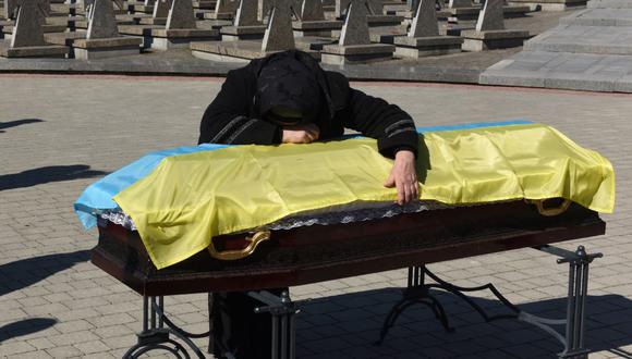 La madre del comandante Ivan Skrypnyk, quien murió durante la invasión rusa de Ucrania, llora sobre su ataúd cubierto con una bandera durante una ceremonia fúnebre en el cementerio de Lychakiv en la ciudad de Lviv, el 17 de marzo de 2022.
(Yuriy Dyachyshyn / AFP).