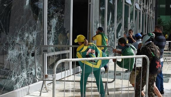Los partidarios del expresidente brasileño Jair Bolsonaro destruyen una ventana de la sesión plenaria de la Corte Suprema en Brasilia.
