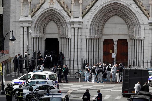 Policías franceses se encuentran en la entrada de la iglesia Basílica de Notre Dame en Niza, Francia, tras un ataque terrorista con cuchillo. (EFE / EPA / SEBASTIEN NOGIER).