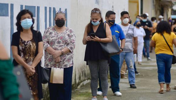 Varias personas acuden a un centro de votación en el colegio Calicuchima con doble mascarilla y un visor para protegerse del covid-19, en Guayaquil (Ecuador). (Foto: EFE/ Marcos Pin).