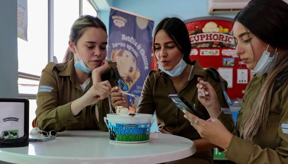 Tres mujeres soldados israelíes disfrutan de un helado en una tienda en Be'er Tuvia, en el sur de Israel, el 21 de julio de 2021, en plena pandemia de coronavirus. (EMMANUEL DUNAND / AFP).