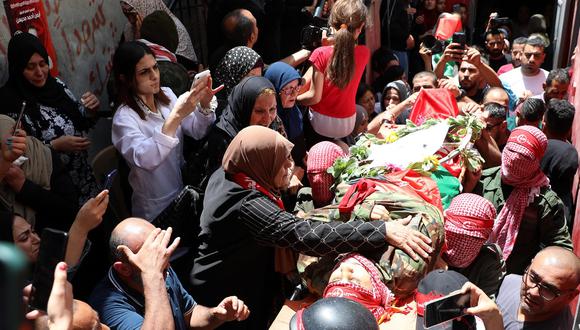 Palestinos llevan el cuerpo de Ayman Muhaisen durante su funeral en el campo de refugiados de Dheisheh, en Cisjordania, cerca de Belén, el 2 de junio de 2022. (EFE/EPA/ABED AL HASHLAMOUN).