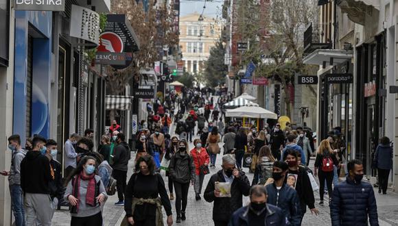 La gente camina por la calle comercial principal de Atenas, el primer día de la reapertura de las tiendas minoristas el 5 de abril de 2021 en medio de la pandemia de coronavirus. (Louisa GOULIAMAKI / AFP).