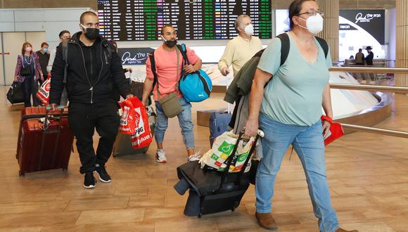 En esta foto de archivo tomada el 1 de noviembre de 2021, los pasajeros caminan con su equipaje a su llegada al aeropuerto Ben Gurion en Israel, cuando el país se reabrió a los turistas vacunados contra el coronavirus. (JACK GUEZ / AFP).