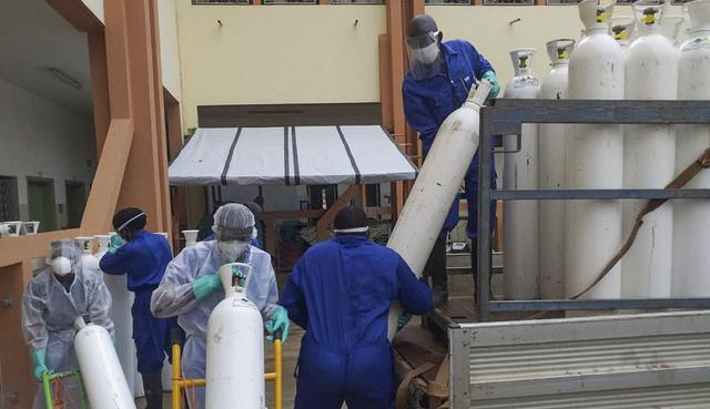 Los trabajadores médicos descargan cilindros de oxígeno en el hospital público de Donka en Conakry, Guinea. Fotografía del 20 de mayo de 2020. (AP /Youssouf Bah).
