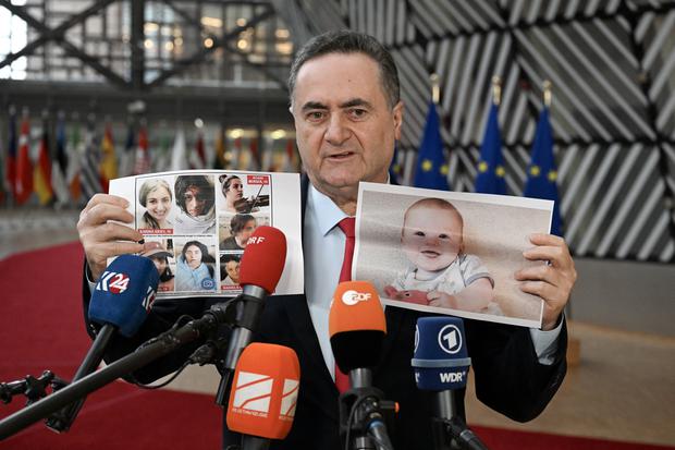 El Ministro de Relaciones Exteriores de Israel, Yisrael Katz, habla con los medios mientras sostiene fotografías de rehenes israelíes retenidos por Hamás en Gaza. (Foto de JOHN TU / AFP).