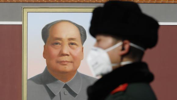 Un oficial de policía chino que usa mascarilla patrulla frente a un retrato del ex líder Mao Zedong en la Plaza Tiananmen de Beijing. (EFE / EPA / WU HONG).