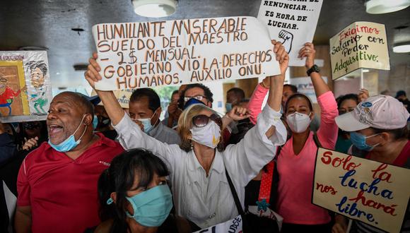 Los maestros venezolanos gritan consignas durante una manifestación exigiendo al gobierno mejoras salariales en el Día del Maestro frente al Ministerio del Trabajo, en Caracas, el 15 de enero de 2021. (Foto de Federico PARRA / AFP)