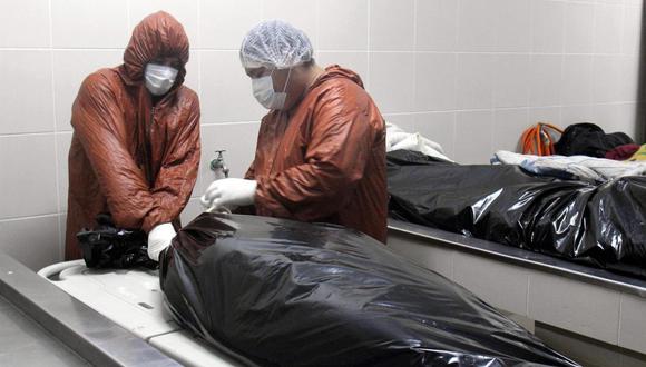 Trabajadores sellan el plástico que envuelve un cuerpo en la morgue del Hospital Pampa de la Isla, el 12 de julio de 2020, en Santa Cruz, Bolivia. (EFE/Juan Carlos Torrejón/Archivo).